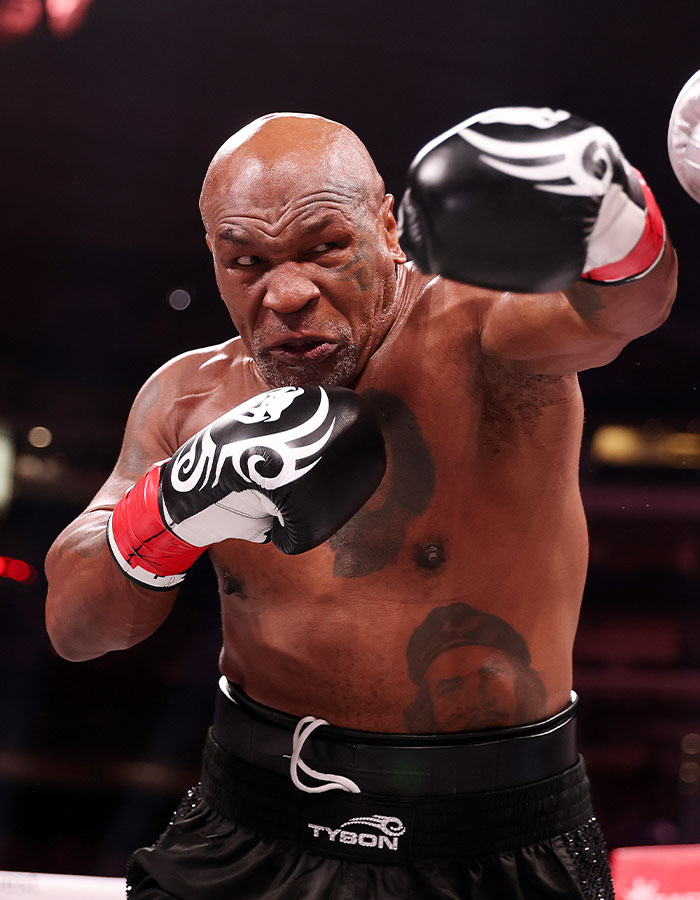 Boxer in action, wearing black gloves and shorts, during a match. Boxer in action, wearing black gloves and shorts, during a match.