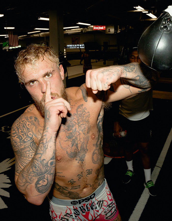 Boxer with tattoos posing in gym, hinting controversial suspension related to Netflix and capital punishment. Boxer with tattoos posing in gym, hinting controversial suspension related to Netflix and capital punishment.
