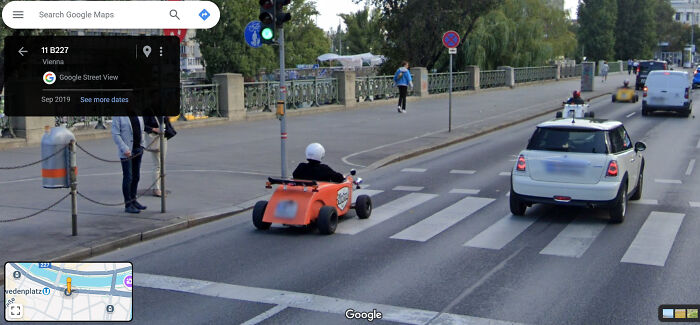 Person driving an orange go-kart on a city street captured on Google Street View, illustrating funny and weird life scenes.