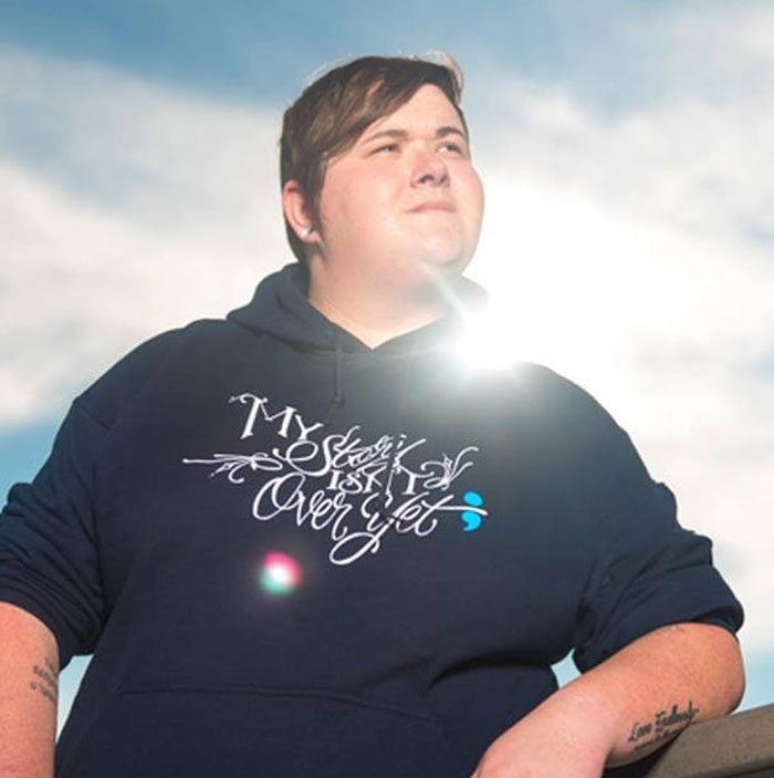 A person wearing a hoodie with the phrase 