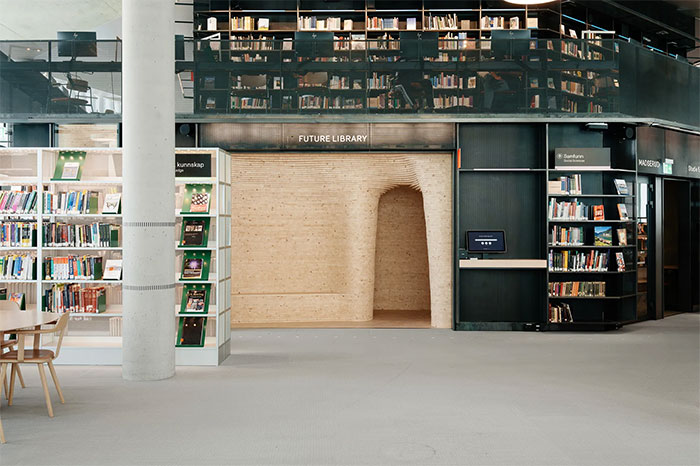 Modern library interior with bookshelves and a unique wooden time capsule doorway.