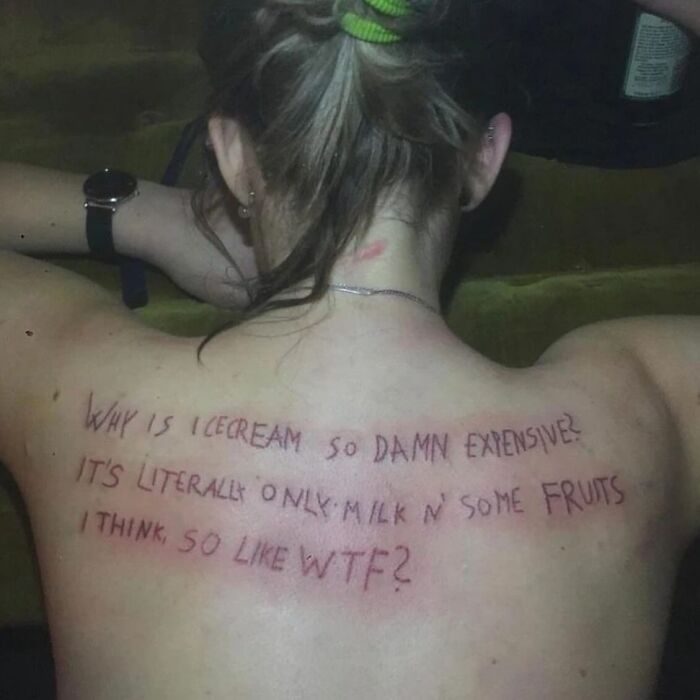 Epic tattoo fail on a woman's back, questioning ice cream prices with humorous, informal script.