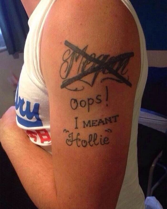 Tattoo fail featuring crossed-out name 'Megan' with text 'Oops! I meant Hollie' on a person's arm.