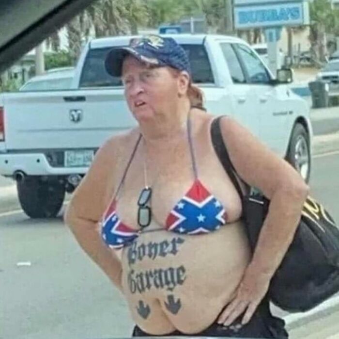 A person on the street displaying epic tattoo fails, wearing a swimsuit and holding a bag.