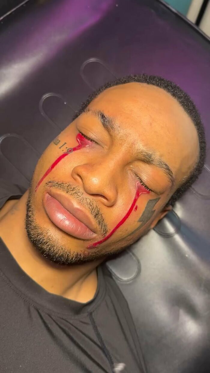 Man with face tattoos featuring red streaks, representing tattoo fails shared online.