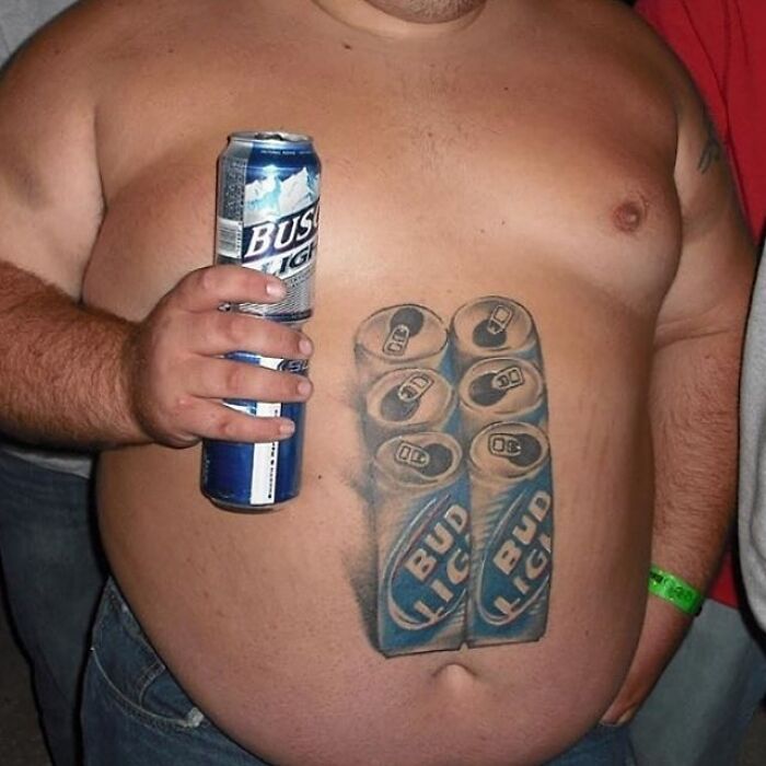 Epic tattoo fail of a six-pack of Bud Light on a man's belly, holding a Busch Light can.