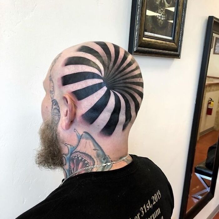 Bald man with spiral tattoo on head, showcasing an epic tattoo fail.