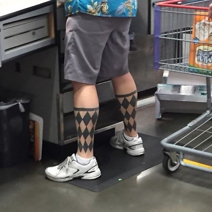Man in store with tattoo resembling argyle socks, wearing shorts and sneakers. Tattoo fail is obvious.