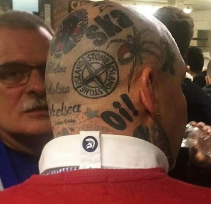 Man with numerous tattoos on his head, featuring logos and text, exemplifying epic tattoo fails.