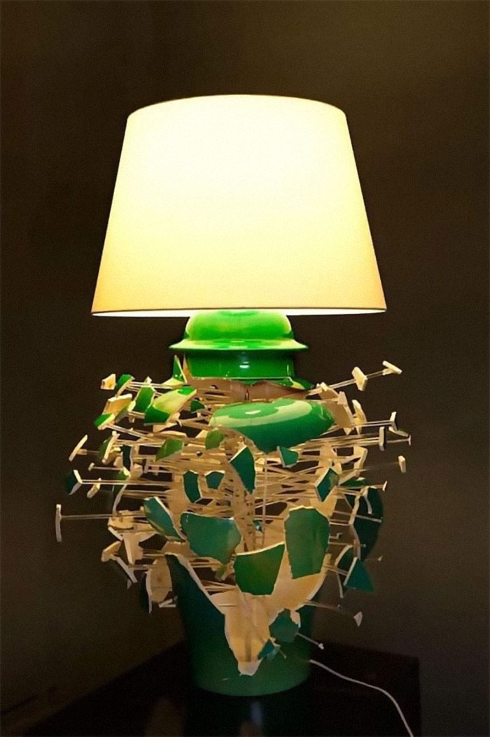 Green lamp with broken porcelain pieces held by wires, a designer creation that will have to be cleaned later