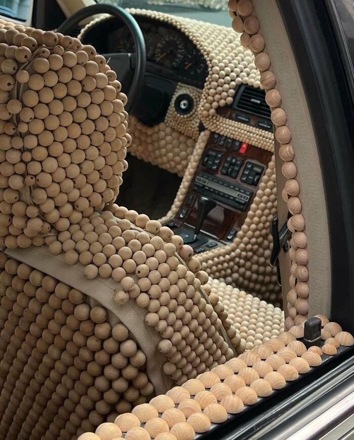 Car interior covered entirely with wooden beads, showcasing a challenging designer creation for cleaning and maintenance.