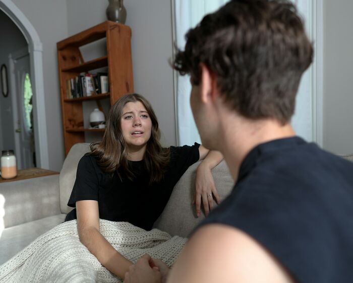 A woman and a man in a living room having a tense conversation, highlighting Nice Guy interactions.