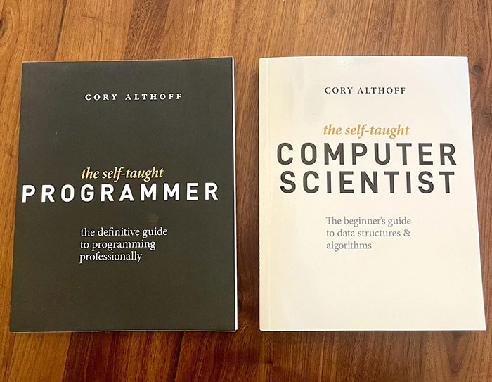 Two books titled "The Self-Taught Programmer" and "The Self-Taught Computer Scientist" by Cory Althoff, Bobbi Althoff&rsquo;s Husband placed on a wooden surface.