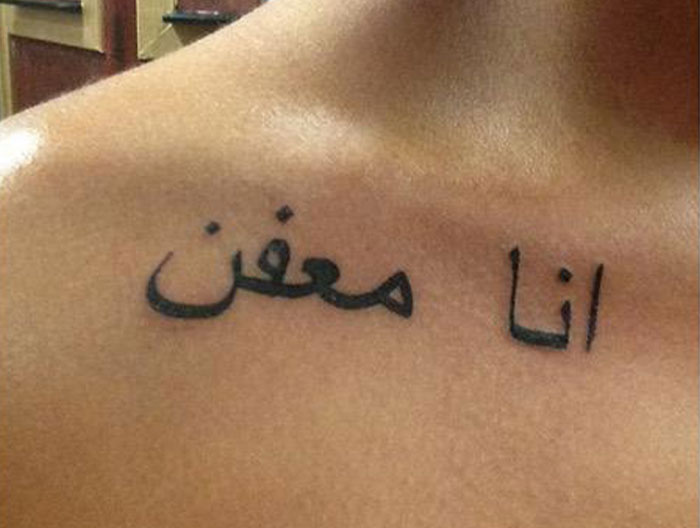 Woman's first tattoo fail with gross meme inked in black script on her shoulder.