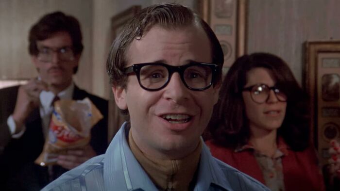 Person with glasses smiling in a retro setting, related to celebrities who faded away.