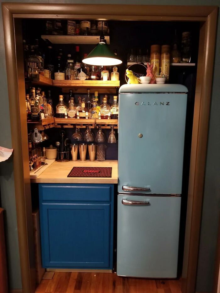 Vintage home bar with retro fridge, colorful bottles, and classic decor, once the height of luxury but now obsolete.