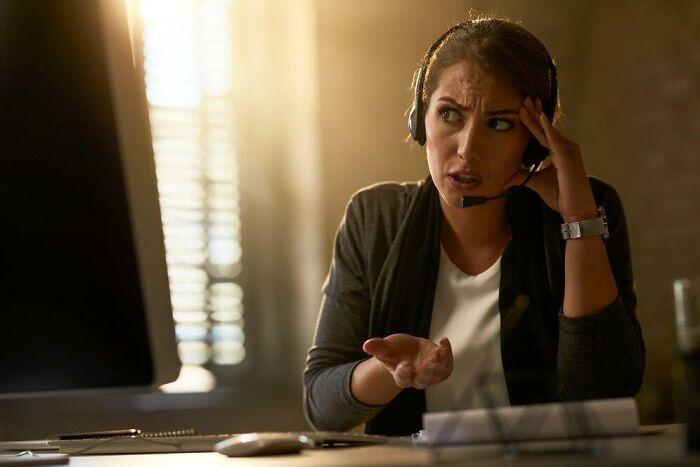 Woman looking frustrated during a phone call with a headset, illustrating things that make people uncomfortable.