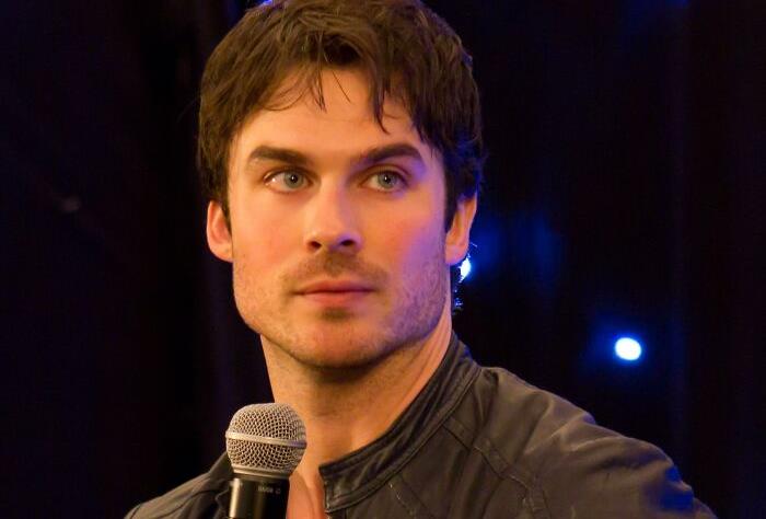 Person holding a microphone in a dimly lit setting, relevant to celebrities-people-lost-respect theme.