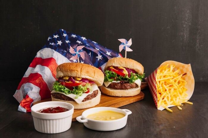 American flag-themed burgers with fries and dipping sauces.