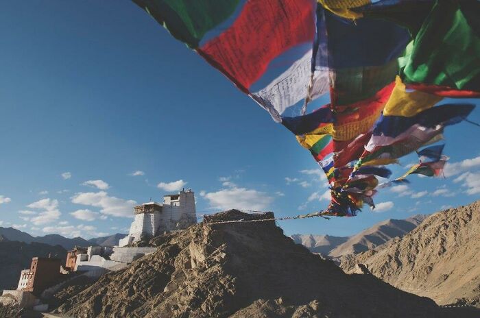 Colorful prayer flags at a hilltop in a mountainous landscape, emphasizing cultural elements in your country.