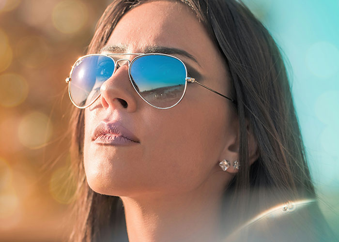 Woman wearing sunglasses, staring thoughtfully, evokes gut feelings and intuition.