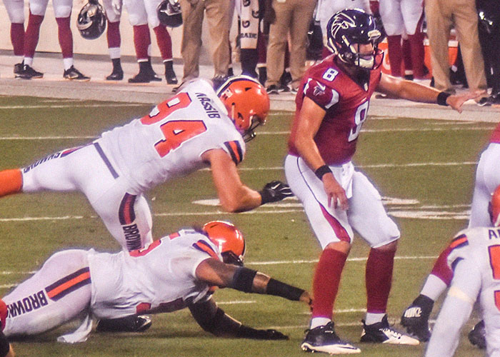 Football players from two teams in action on the field, capturing a moment of intense play during a game.