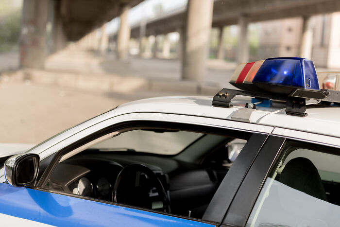 Police car under a bridge with a flashing light, related to secret confessions.