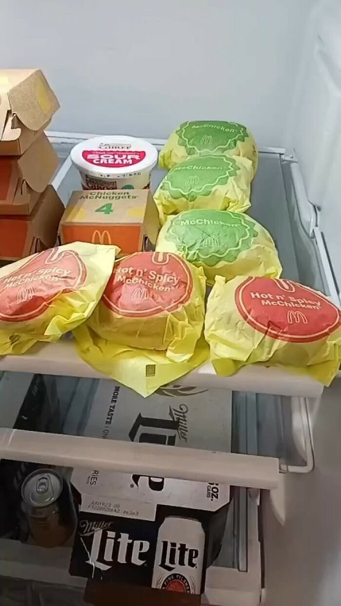 Dude fridge packed with fast food and beer, showcasing a chaotic assortment of McDonald's items and Miller Lite.