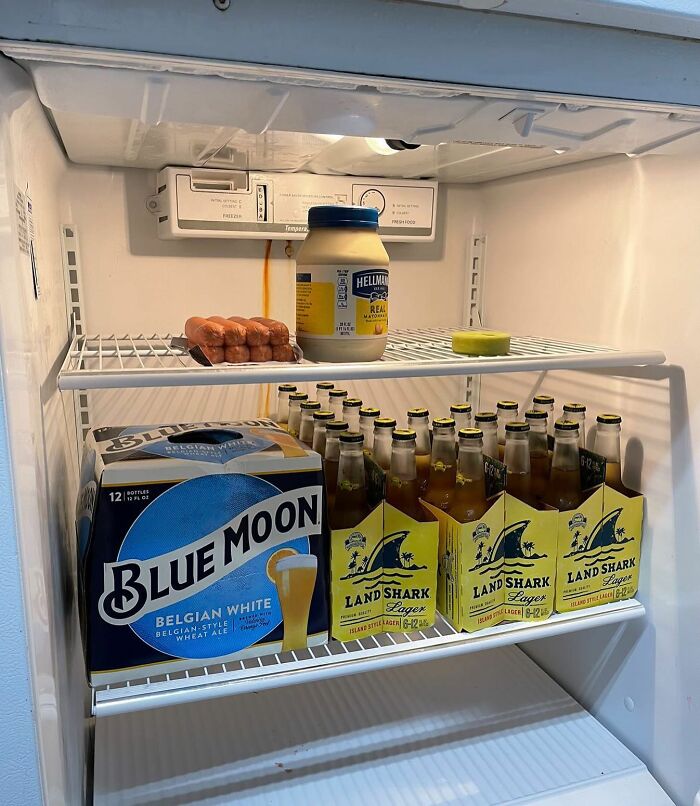 A typical "dude fridge" with beer, sausages, and a jar of mayonnaise.