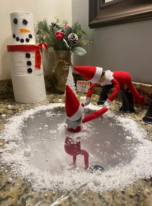 Elf On The Shelf idea with one elf rescuing another from a sink ice pond marked Danger Thin Ice with fake snow.