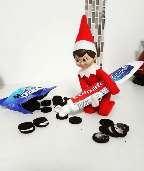 Elf on the Shelf idea showing elf squeezing toothpaste onto Oreo cookies for a funny holiday mischief prank setup.