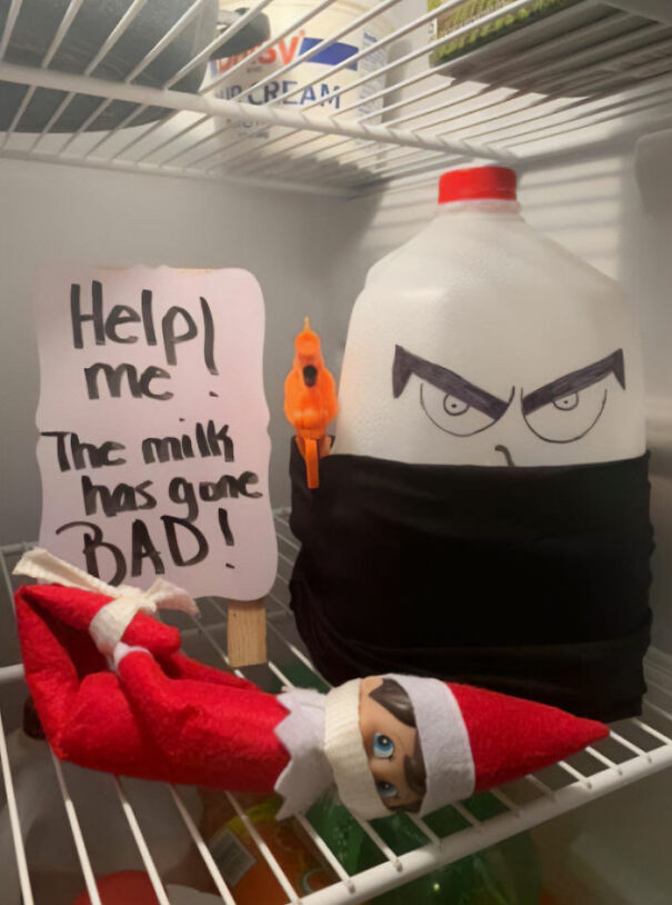 Elf On The Shelf idea with an elf tied up in fridge next to a menacing milk jug and a sign about bad milk.