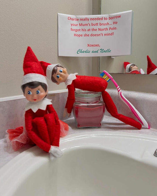 Two Elf On The Shelf dolls on bathroom counter with toothbrush and funny apology note for borrowing it