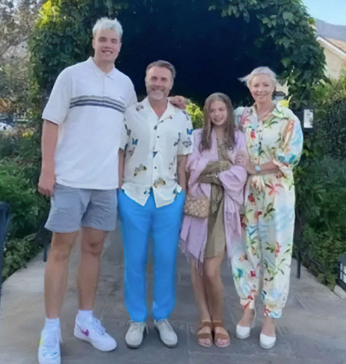 Family photo featuring British star Gary Barlow's son, noted for his towering height, alongside other family members.