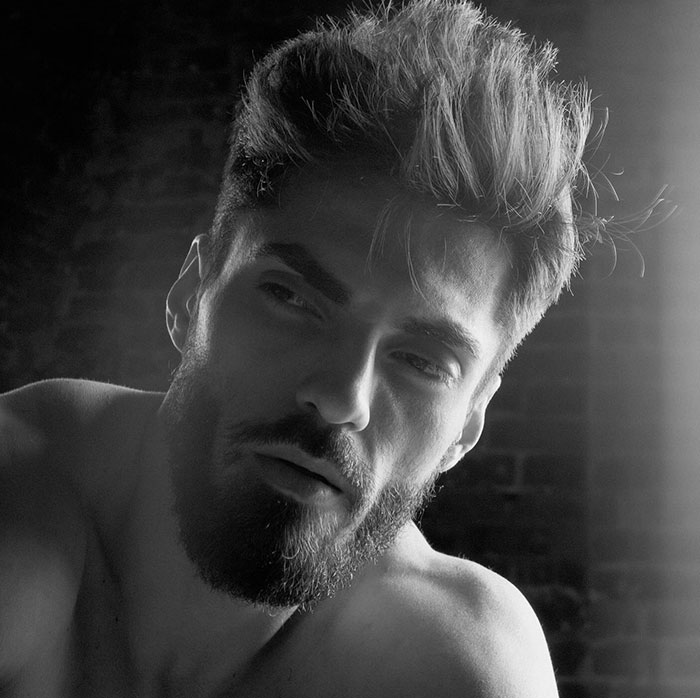 Grayscale close-up of a man with sharp jawline and beard, embodying Giga Chad meme masculinity.