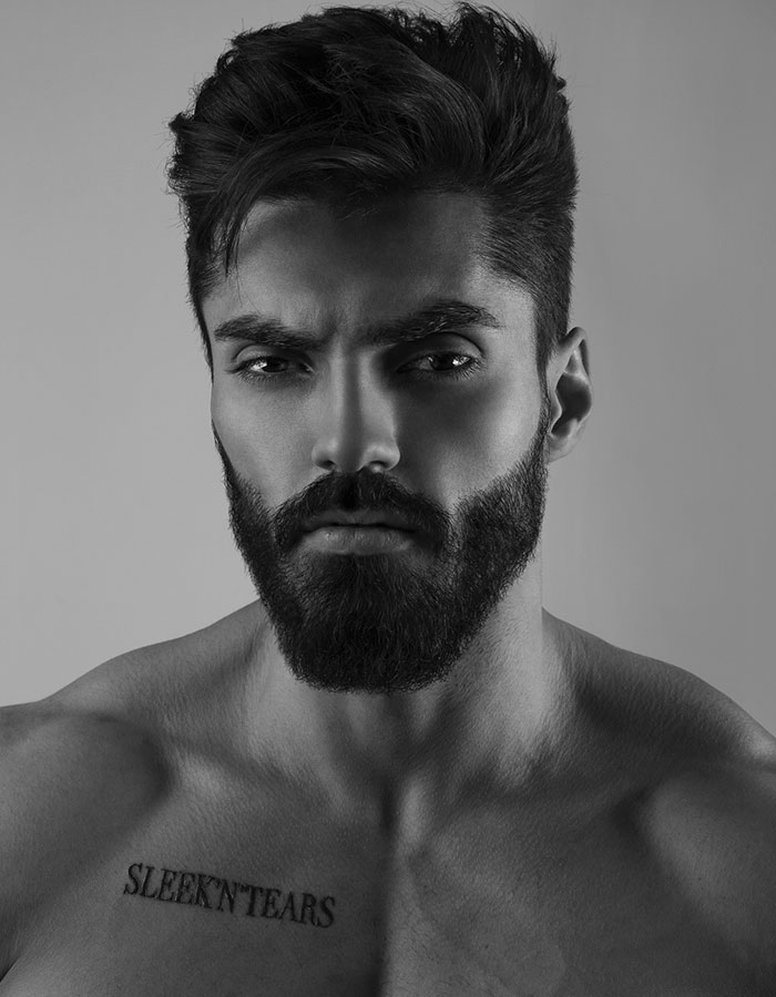 Grayscale portrait of a muscular man with sharp features and tattoo, tied to the Giga Chad meme representing masculinity.