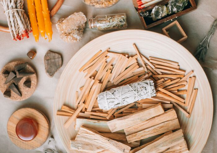 Aromatherapy items like sage, incense sticks, and candles on a table, evoking the smell of happiness.