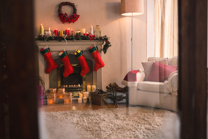 Cozy living room decorated for Christmas with stockings on the fireplace mantel, creating a smell of happiness.