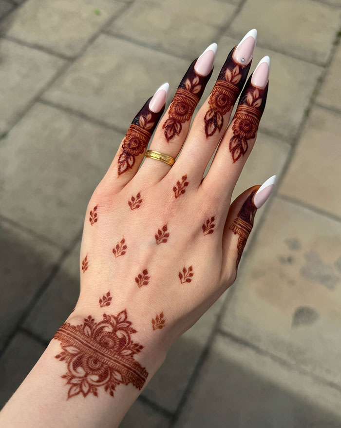 Intricate henna tattoo design on a hand, showcasing stunning patterns on fingers and wrist.