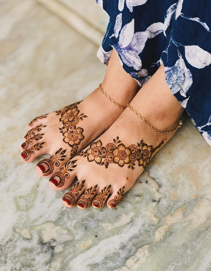 Henna tattoo design on feet with floral patterns, showcasing artistry and cultural beauty.