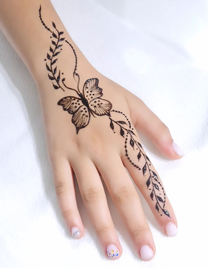Henna tattoo design on hand with butterfly and leaf patterns, showcasing intricate artistry.