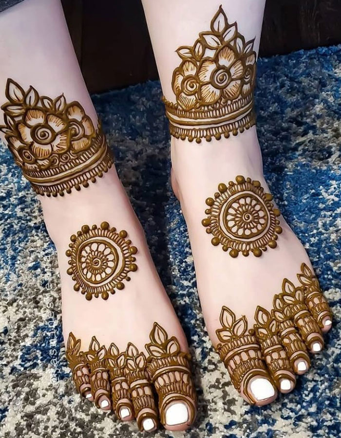 Elaborate henna tattoo designs on feet showcasing intricate patterns and motifs.