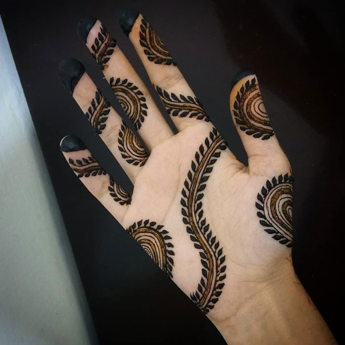 Hand with intricate henna tattoo design, showcasing stunning patterns and artistry.
