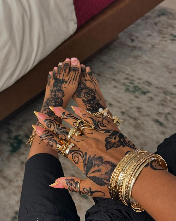 Intricate henna tattoos on hands and feet with jewelry, showcasing stunning design ideas.
