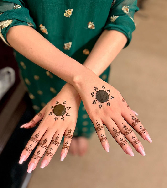 Intricate henna tattoo design on hands, showcasing cultural art in a vibrant setting.