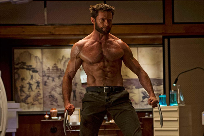 An actor flawlessly embodying a muscular, intense character with claws, standing in a room with various objects.