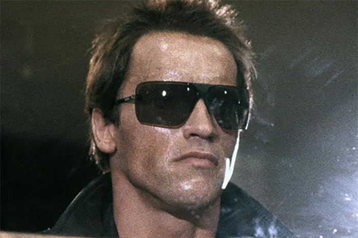 Actor in a classic film role, wearing sunglasses, portraying a character flawlessly.