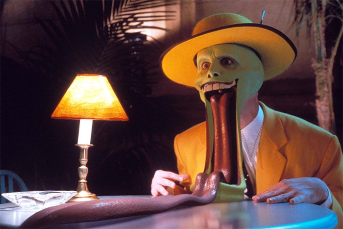 Actor in a yellow suit and hat, with a cartoonishly exaggerated expression next to a lamp, embodying a flawless role performance.