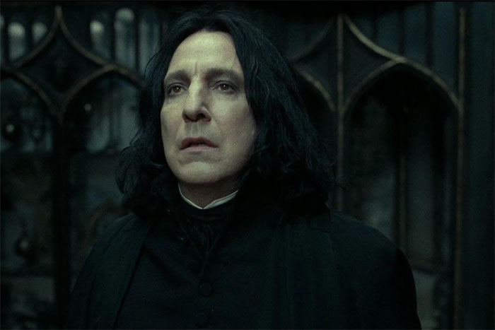 Actor portraying a role flawlessly in a dramatic scene, wearing a dark robe in a gothic setting.