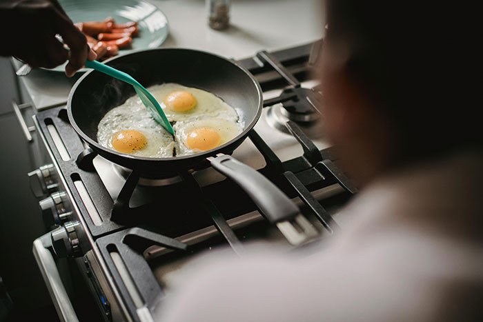 Cooking eggs in a pan, an essential life skill for adults in the kitchen.